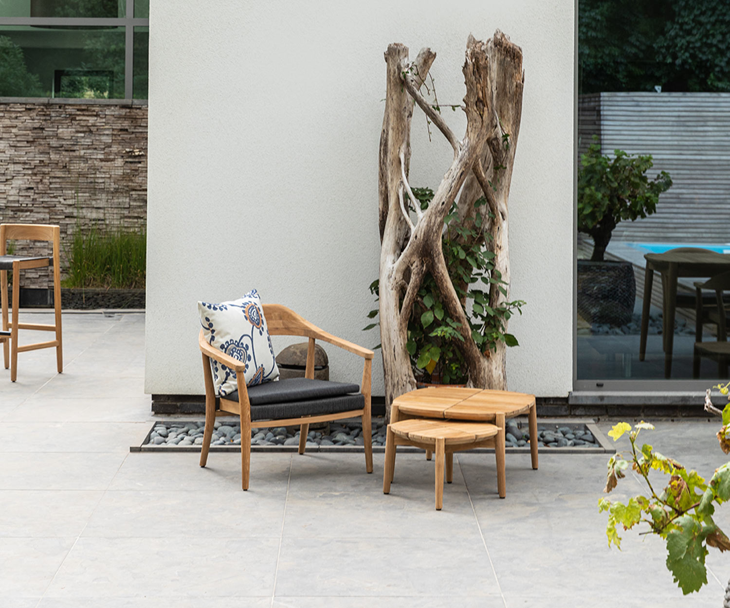 Tavolo quadrato da esterno Oasiq Copenhagen con sedia e albero in terrazza Tavolo quadrato da esterno Oasiq Copenhagen con sedia e albero in terrazza