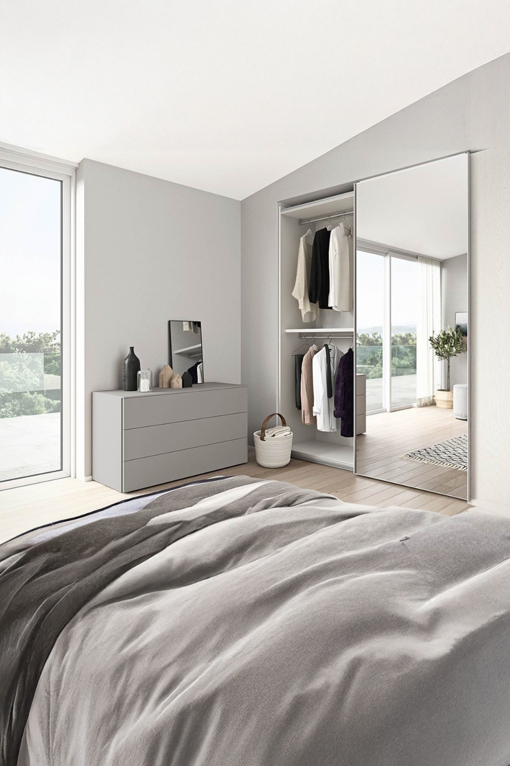 armadio con anta a specchio e cassettiera con specchio a terra in una camera da letto arredata in modo accogliente