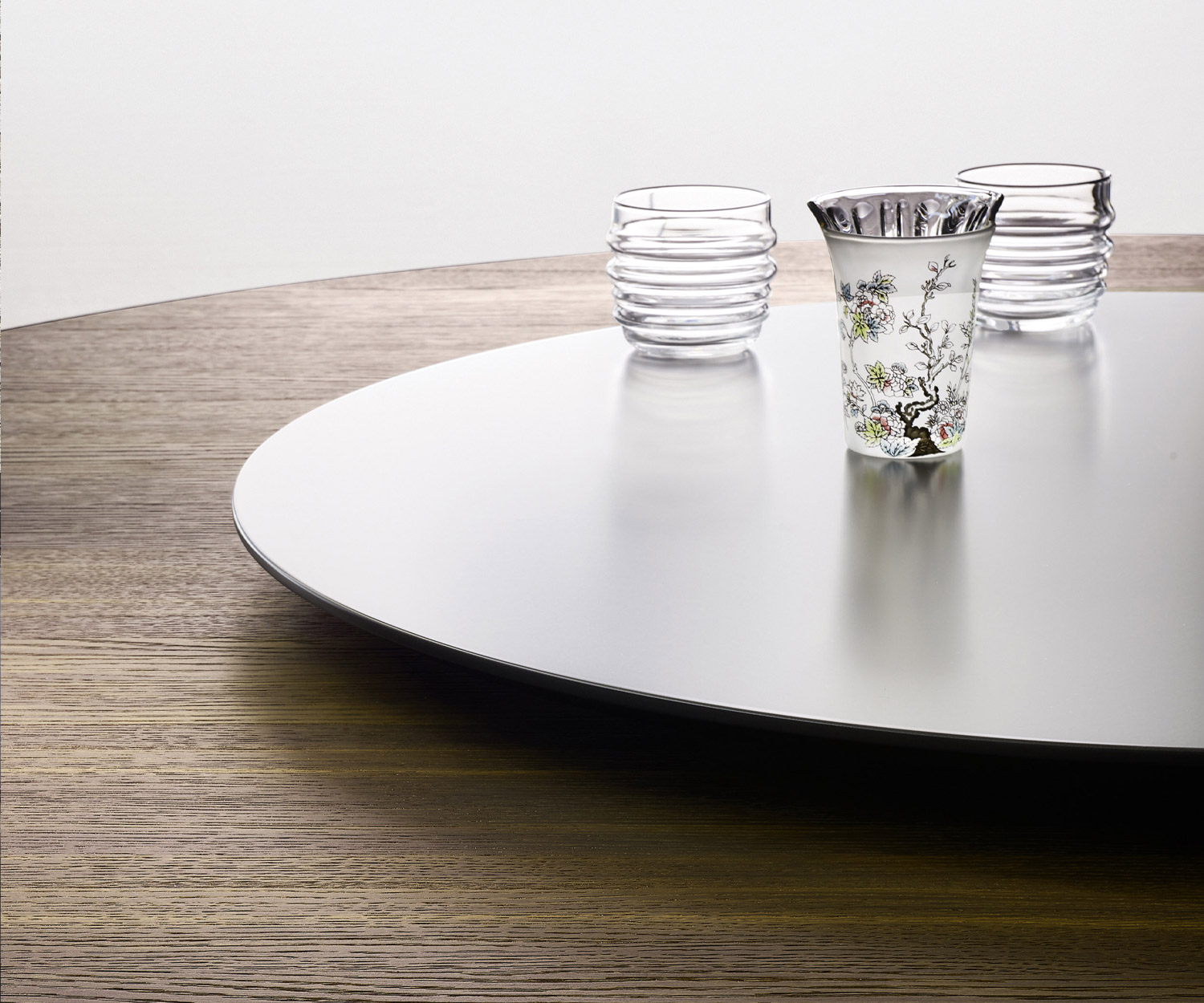 Particolare del piano girevole del tavolo da pranzo Livitalia Convivio con bicchieri su piano in rovere