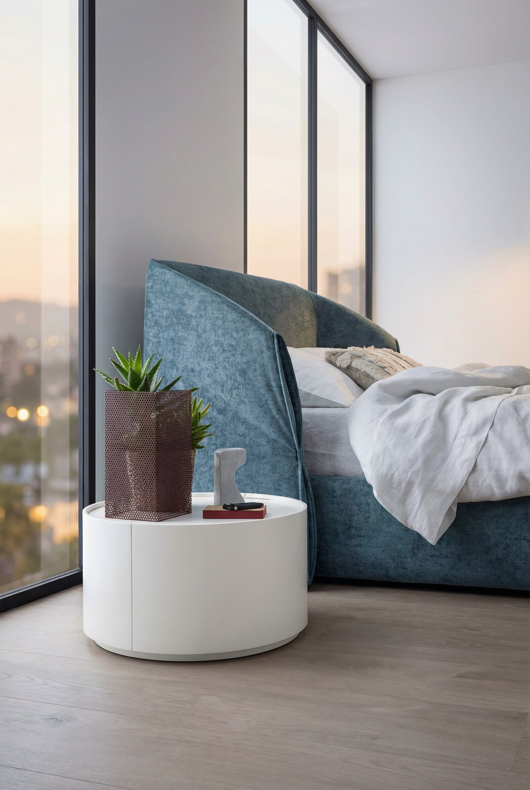 Tavolino cilindrico Novamobili Allout in bianco accanto a un letto moderno Tavolino cilindrico Novamobili Allout in bianco accanto a un letto moderno