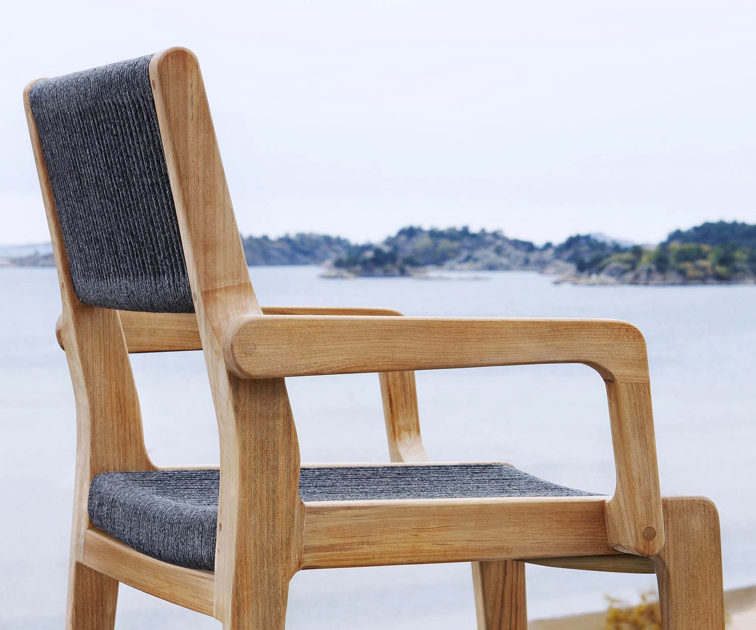 Moderna Oasiq Sedia di design Skagen in teak con braccioli imbottiti in antracite Moderna Oasiq Sedia di design Skagen in teak con braccioli imbottiti in antracite