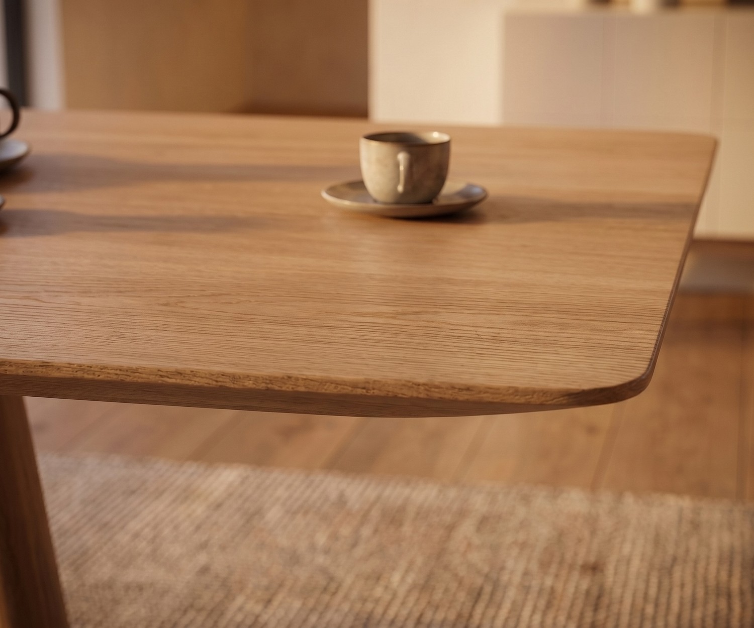 Tavolo da pranzo mos-i-ko 001 a in rovere, dettaglio dell'angolo arrotondato del piano in legno in una sala da pranzo moderna.