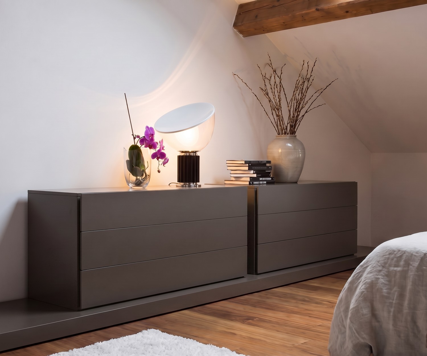 Comò Easy 3 cassetti Novamobili in camera da letto, cassettiera moderna grigia sotto mansarda con lampada di design.