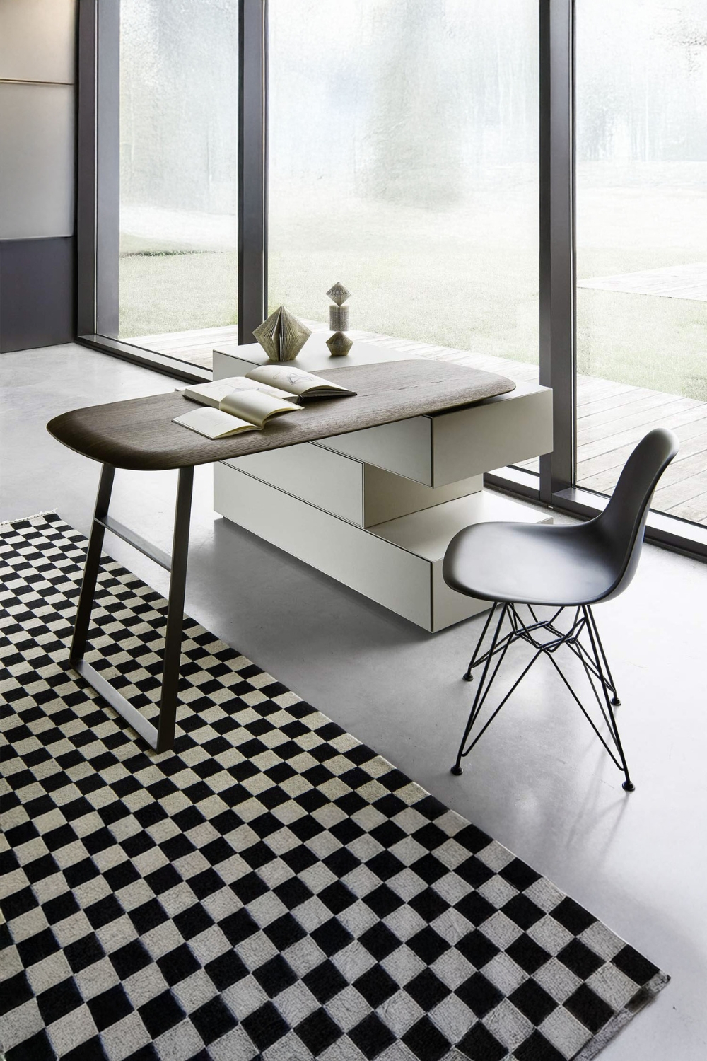 postazione-di-lavoro-moderna-con-elegante-cassettiera-di-design-e-tavolo-girevole-accanto-a-tappeto-con-motivo-a-scacchiera