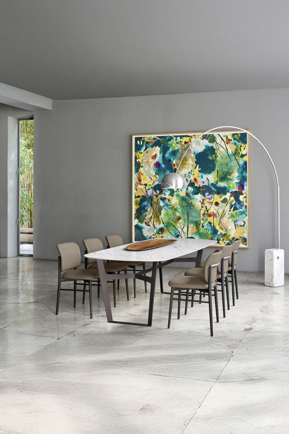 ampia-sala-da-pranzo-piastrellata-con-un-gruppo-da-pranzo-dal-design-minimalista-e-lampada-ad-arco-davanti-a-un-murale-astratto-colorato