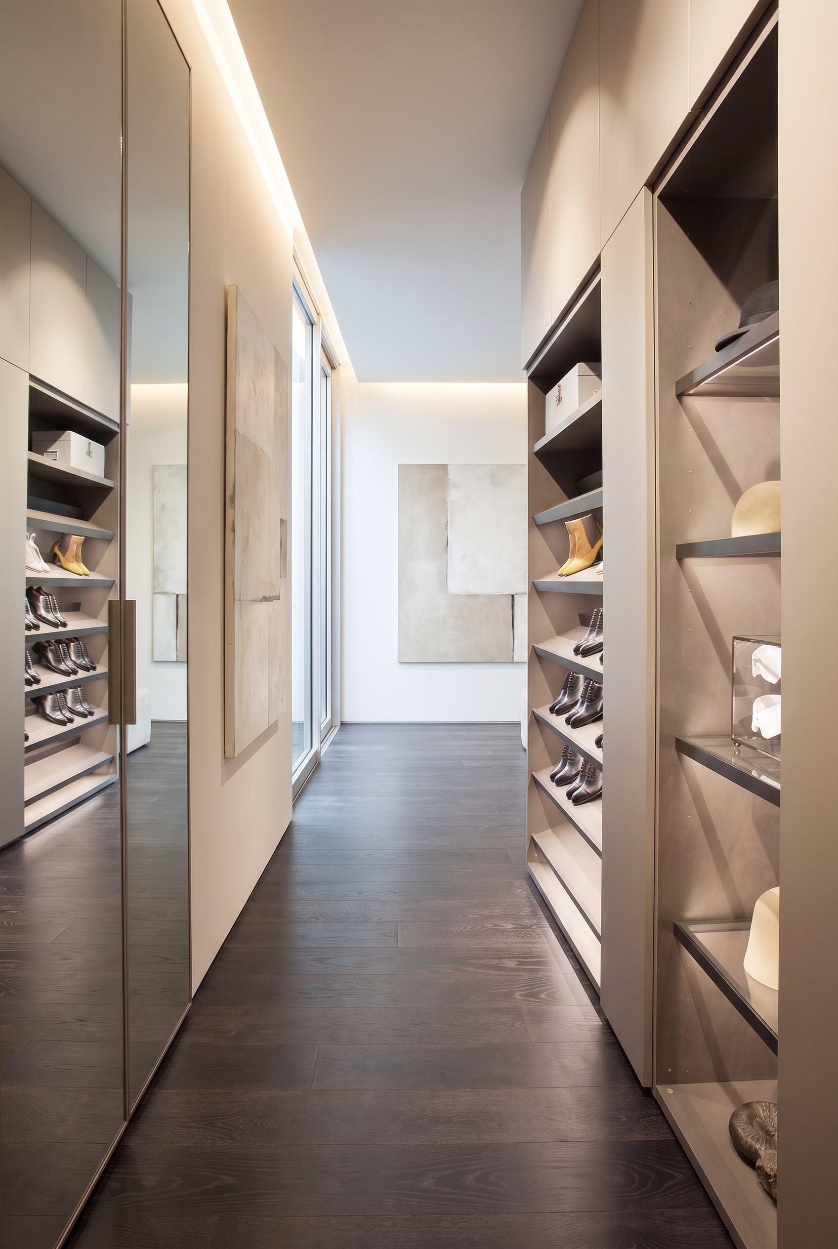 Ein leicht geöffneter moderner Schuhschrank im Flur, der im Inneren schräge Ablagen mit integrierter LED-Beleuchtung zeigt.