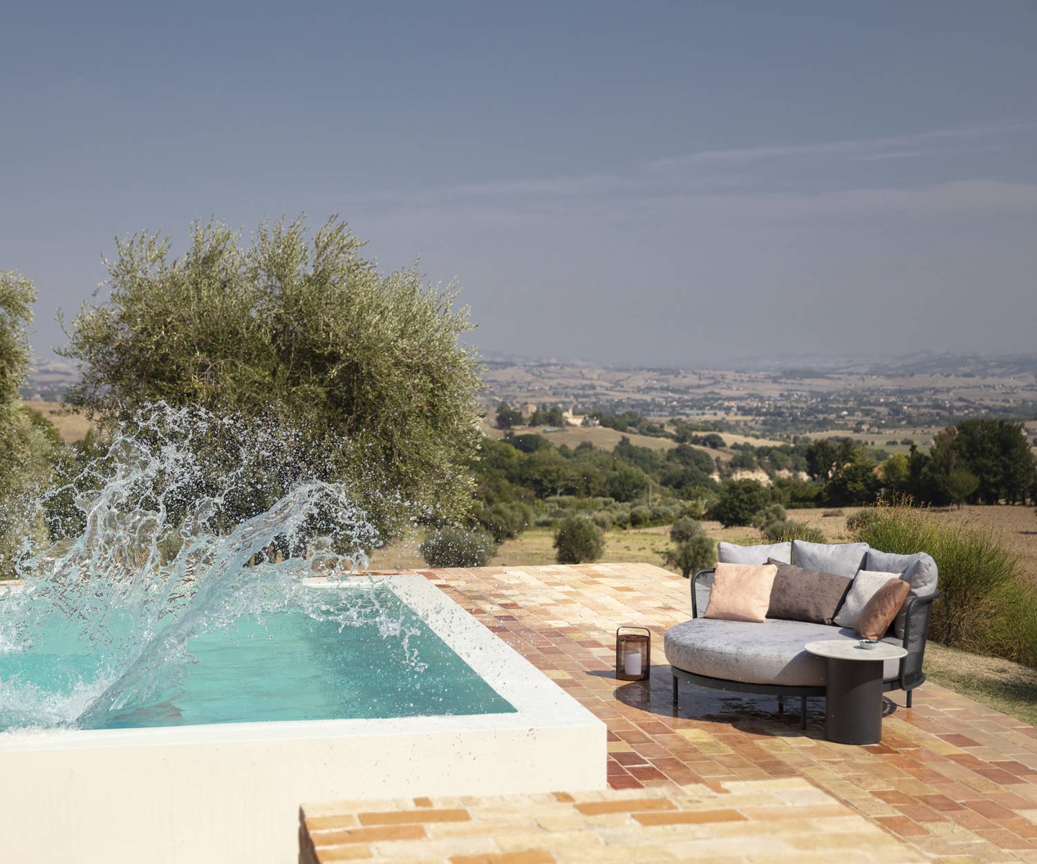 Lettino da giorno rotondo Baza che si asciuga al sole dopo aver sguazzato in piscina Lettino da giorno rotondo Baza che si asciuga al sole dopo aver sguazzato in piscina