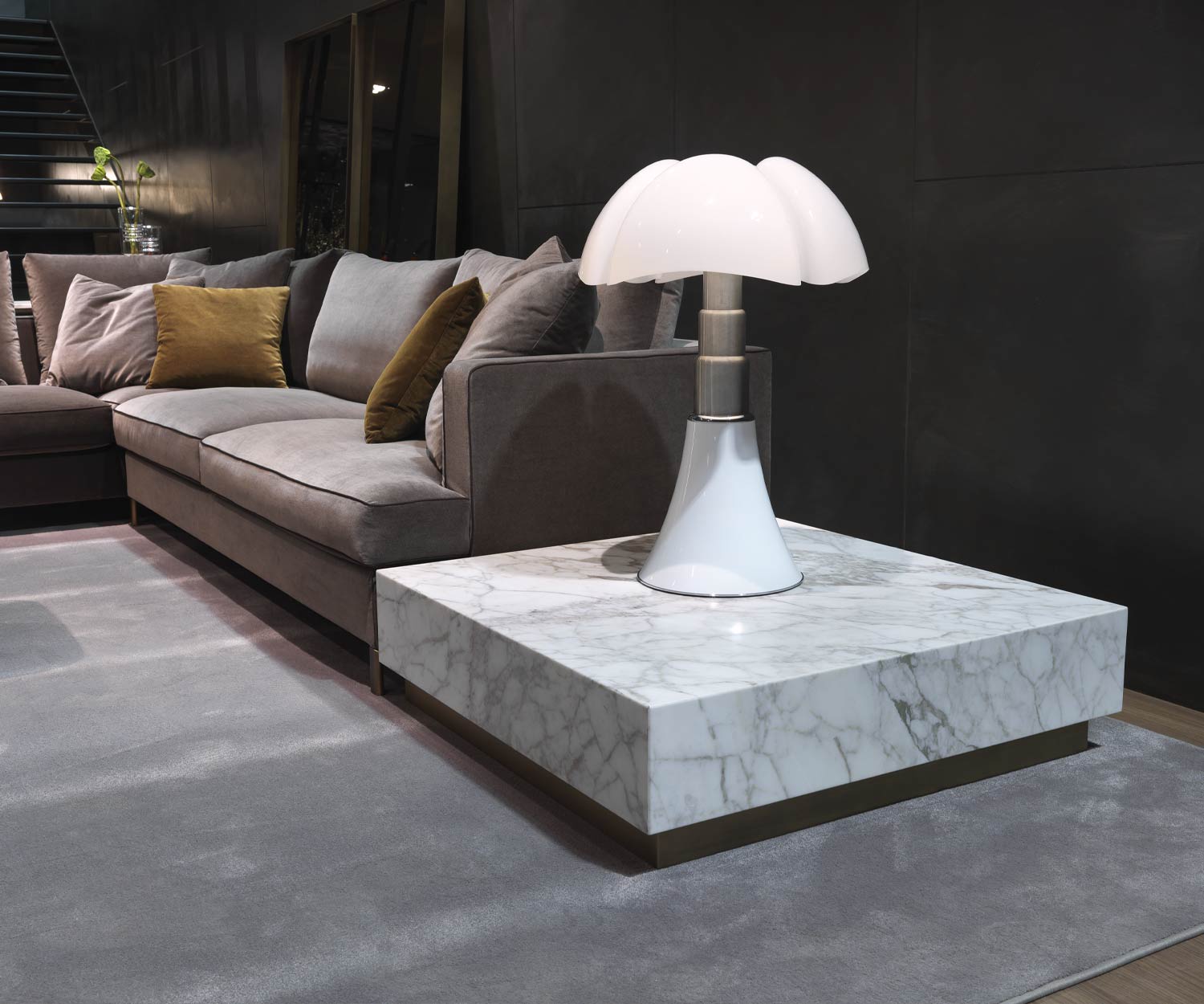 Tavolino in marmo bianco Thor di Marelli a Carrara accanto al divano del soggiorno