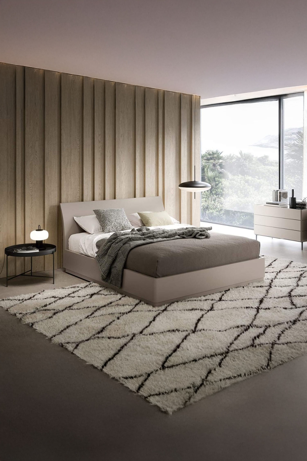 camera da letto arredata in beige con grande finestra e mobili moderni