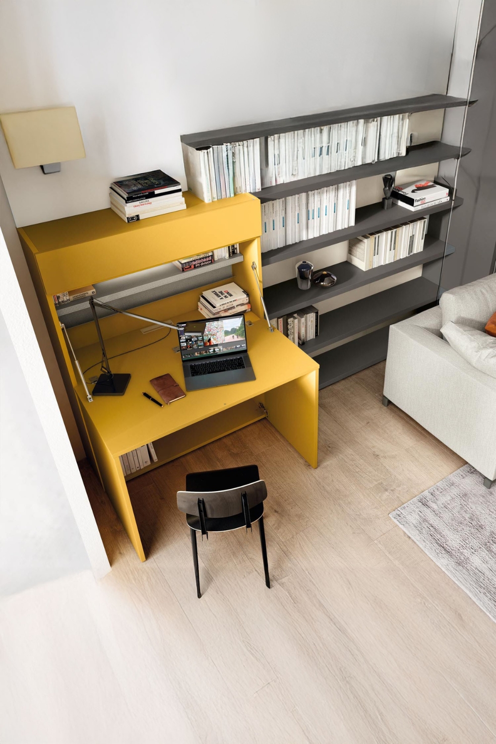 credenza-gialla-con-funzione-scrivania-accanto-a-uno-scaffale-a-parete-aperto-e-un-divano-chiaro