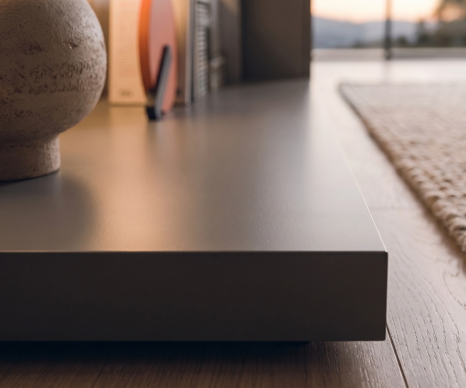 Pedana TV Livitalia Easy per il soggiorno. Zoccolo basso moderno grigio scuro su pavimento in legno.