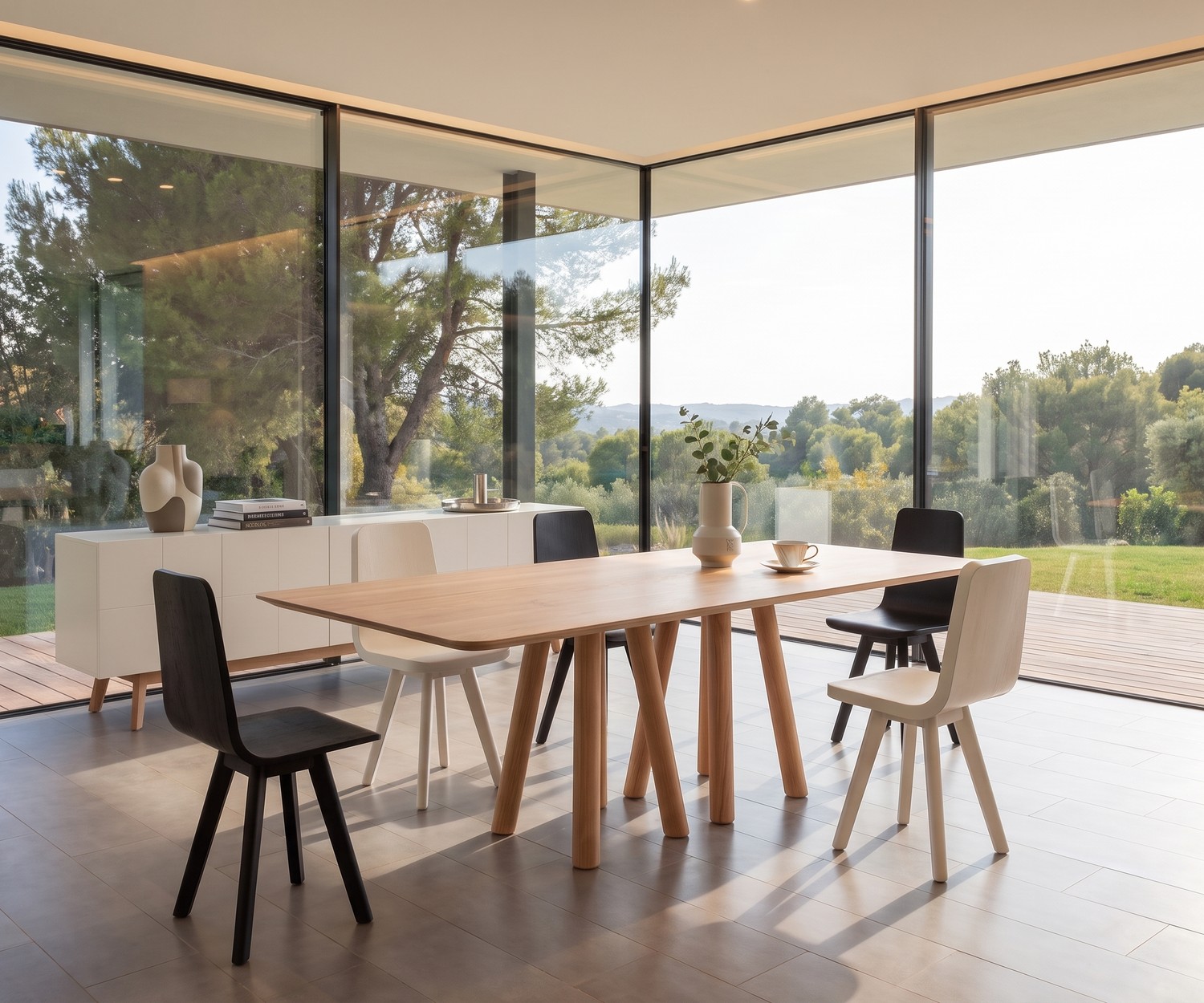 Tavolo da pranzo design al2 mos-i-ko in legno in una sala da pranzo moderna con ampie vetrate e sedie minimaliste.