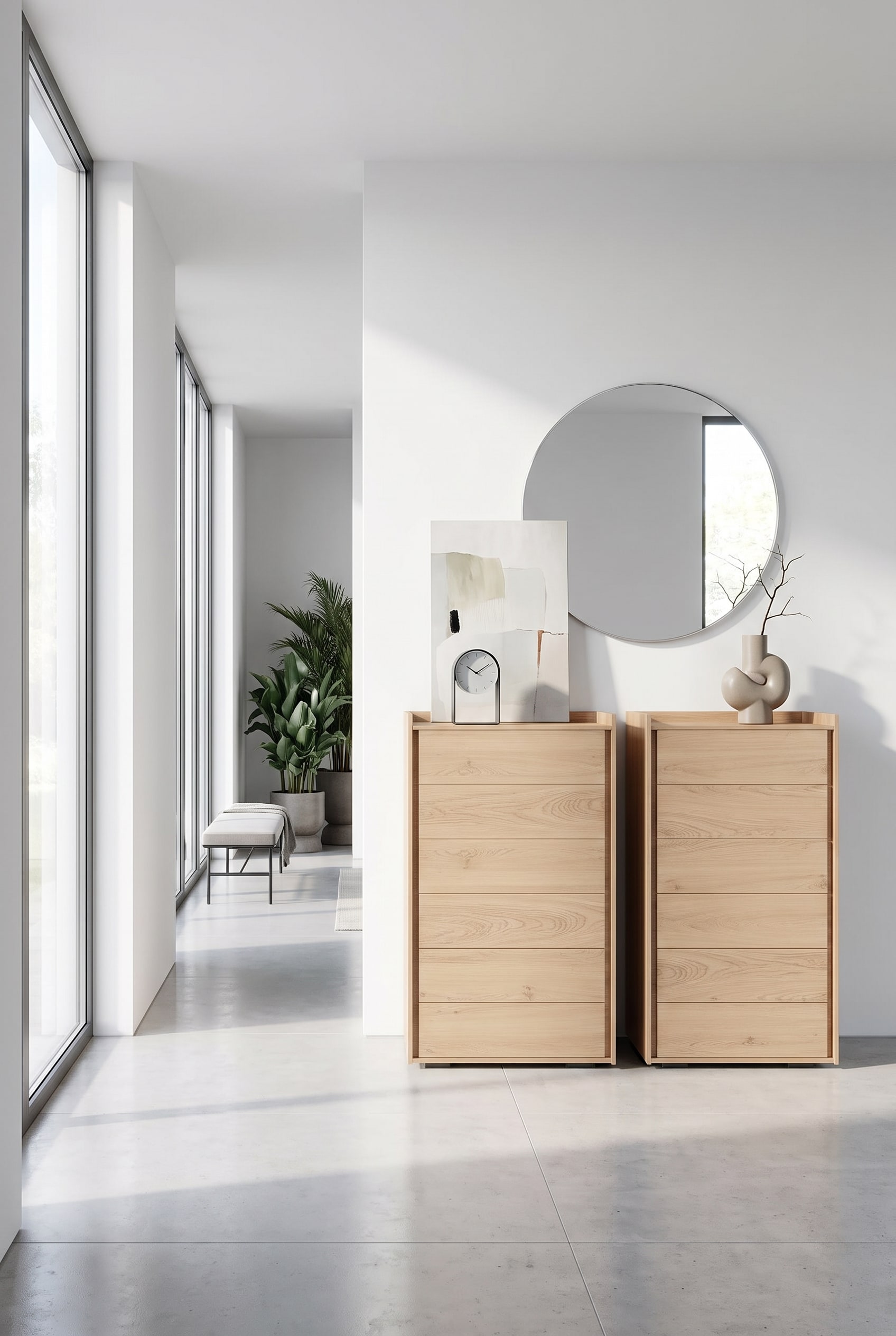 Schmale Hochkommode aus hellem Holz im Flur, auf der Deckplatte eine edle Tischuhr und ein minimalistisches Gemälde angelehnt