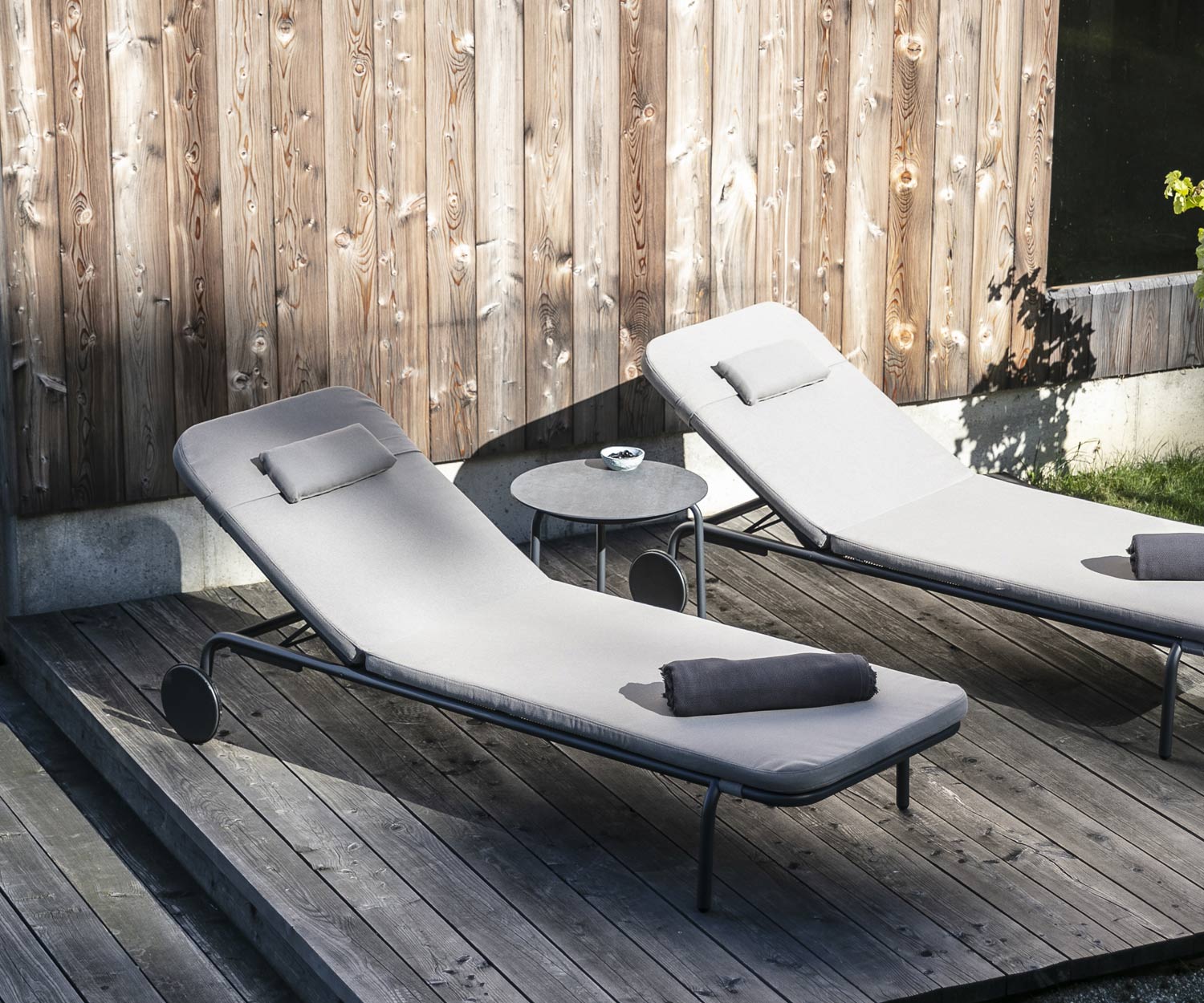 Tavolino di design Starling di Todus con due lettini da giardino su una veranda in legno