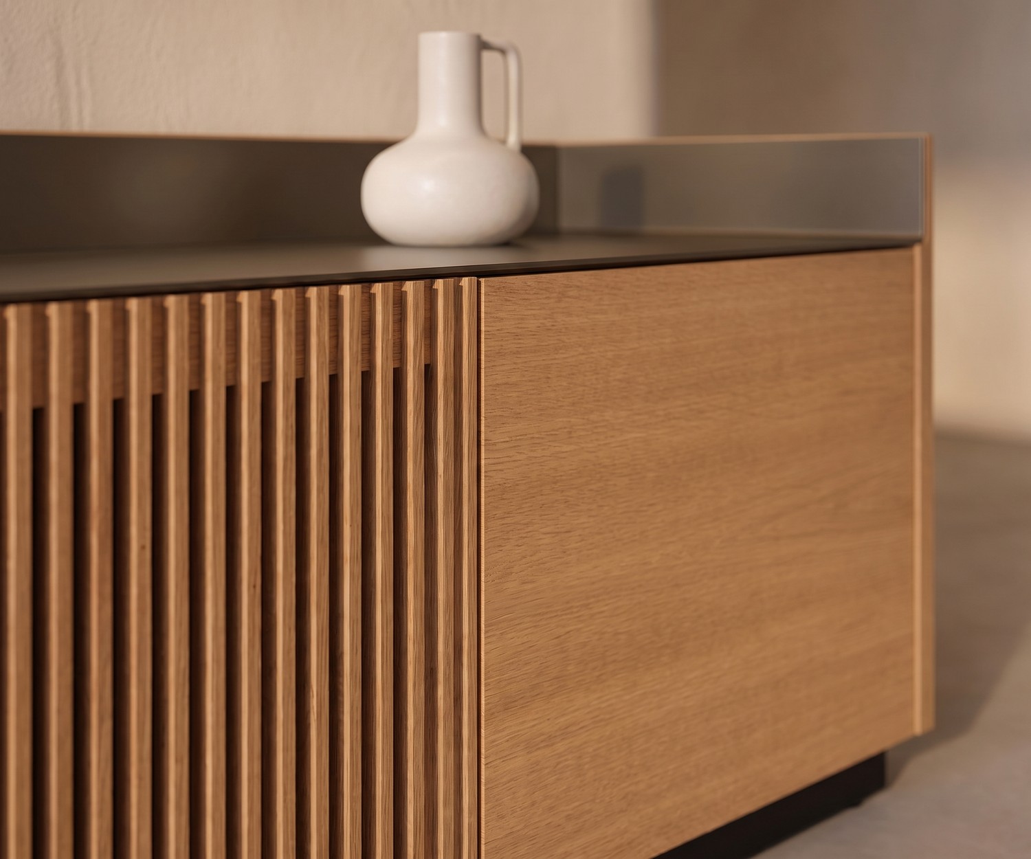 Mobile TV Lowboard Punt Stockholm in rovere con frontale a doghe e top in alluminio in un soggiorno moderno.
