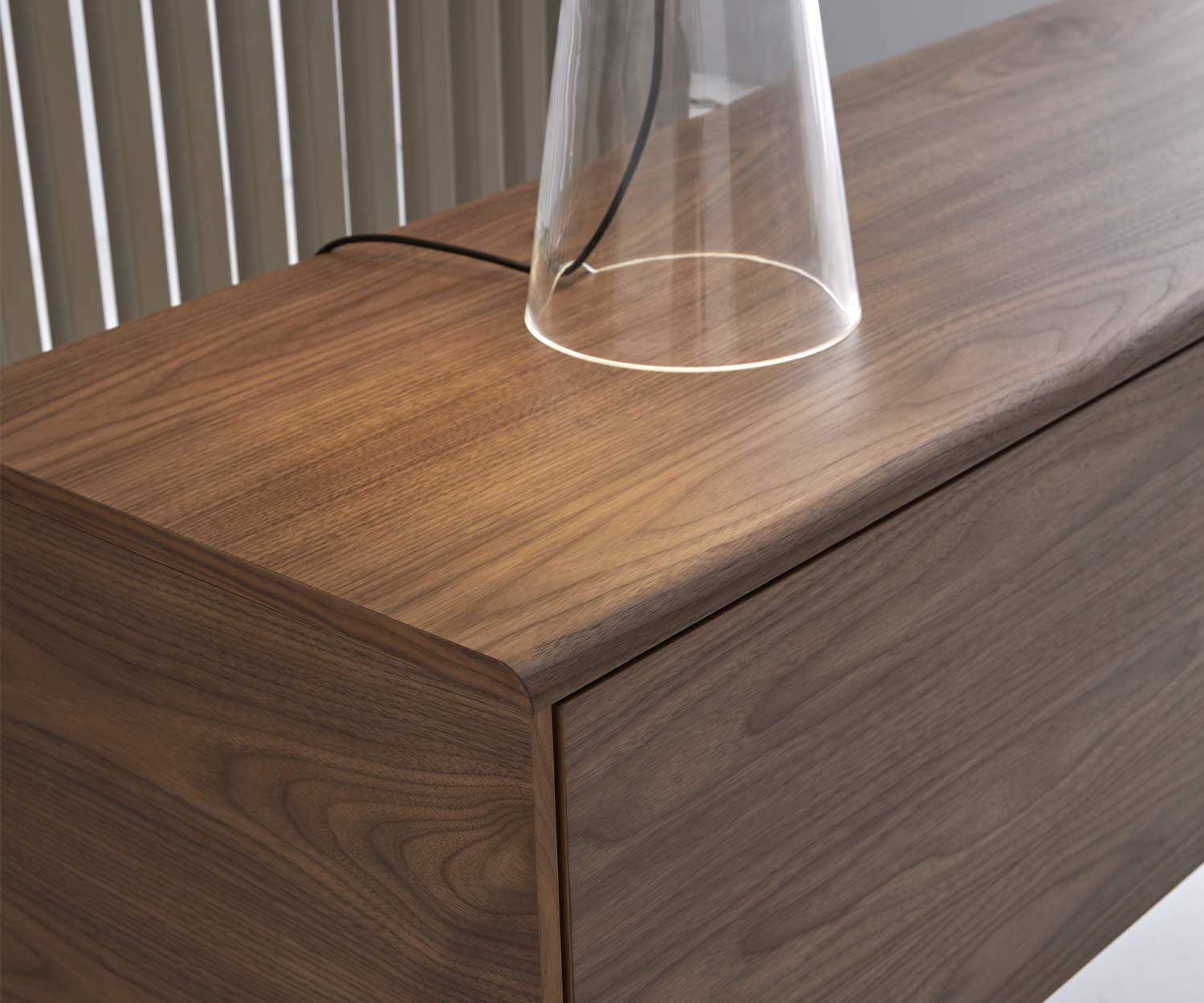 Dettaglio credenza dal design esclusivo, piano con bordo arrotondato in noce Dettaglio credenza dal design esclusivo, piano con bordo arrotondato in noce