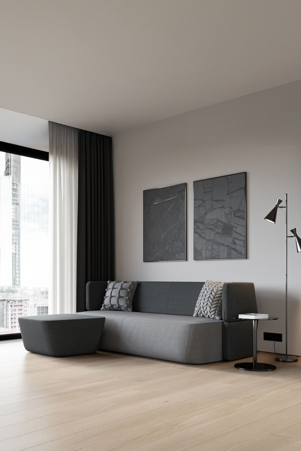 divano-letto-grigio-con-bordi-arrotondati-completato-da-uno-sgabello-abbinato-e-un-tavolino-rotondo