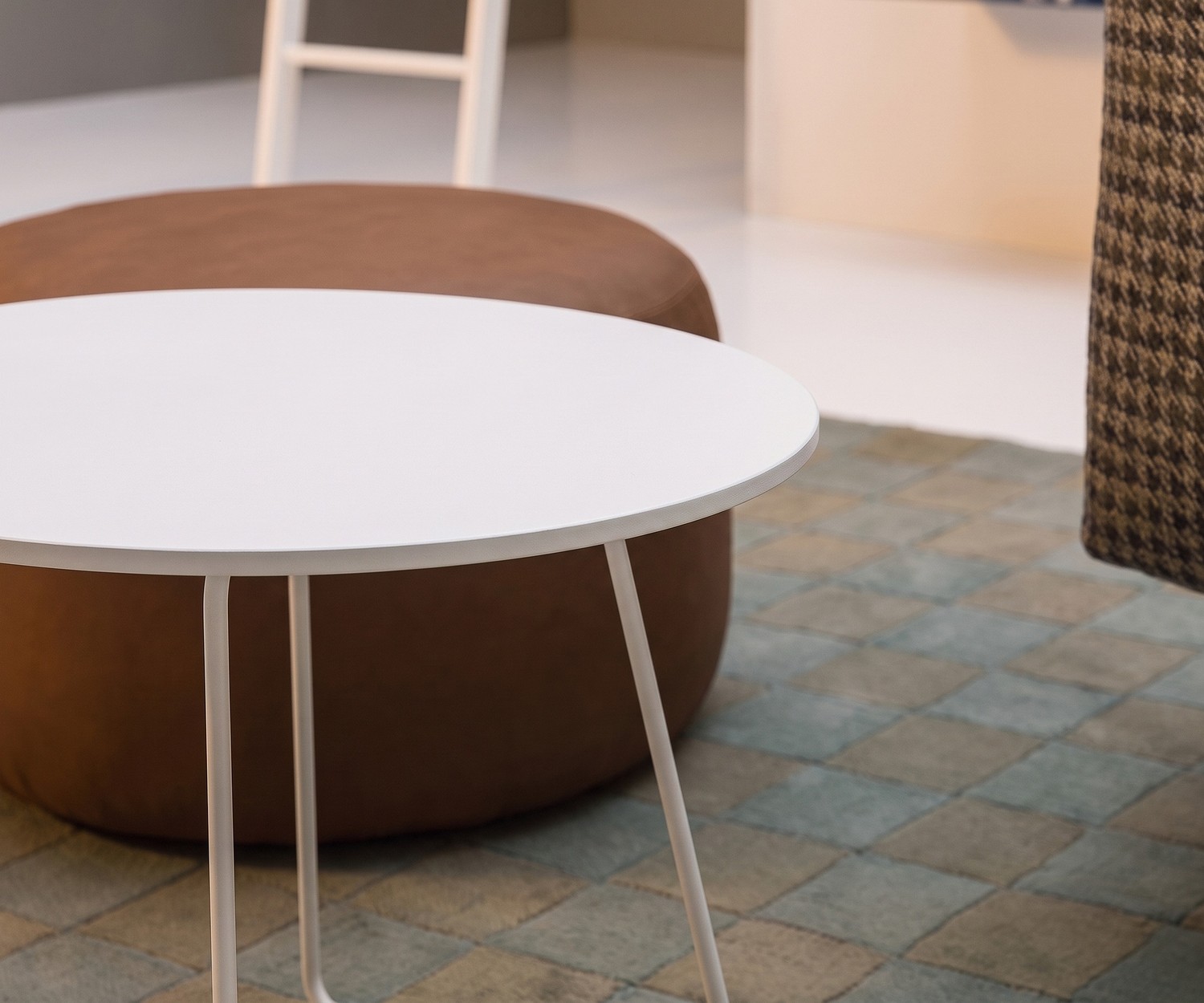 Tavolino da salotto Novamobili Orbis in soggiorno accanto a un pouf marrone, tavolino rotondo bianco.